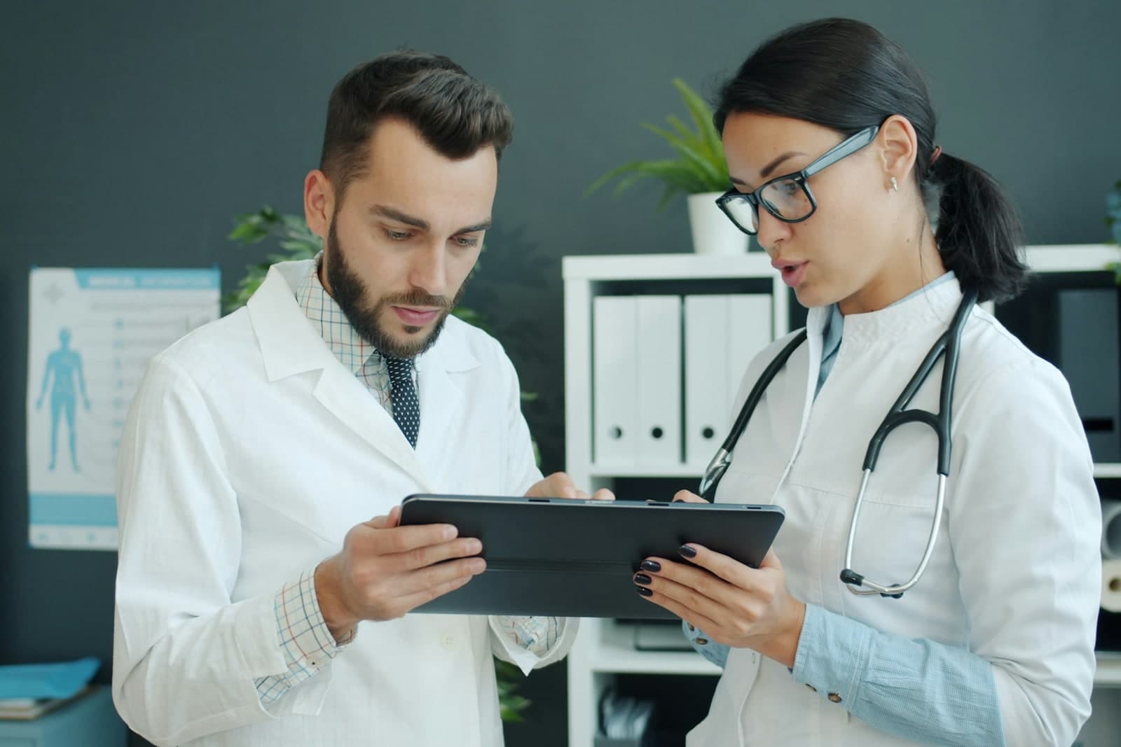 Two clinicians reviewing information on a tablet together.