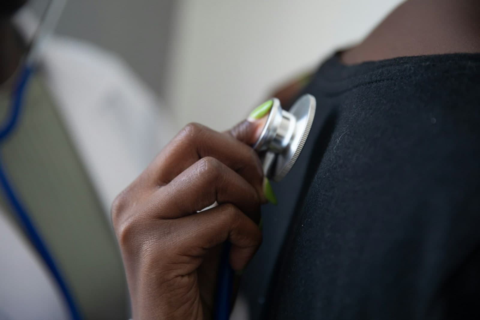 Hands holding a healthcare device during a clinical check-up.